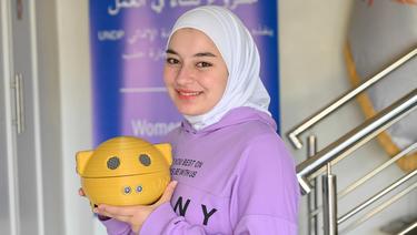 Woman posing for the camera carrying a yellow object.